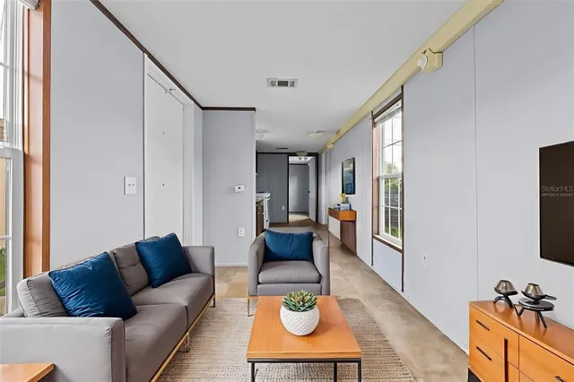 a view of a hallway with wooden floor and windows
