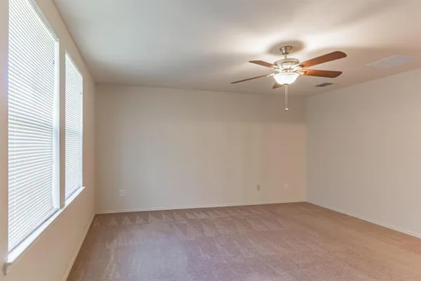 an empty room with a window and a fan