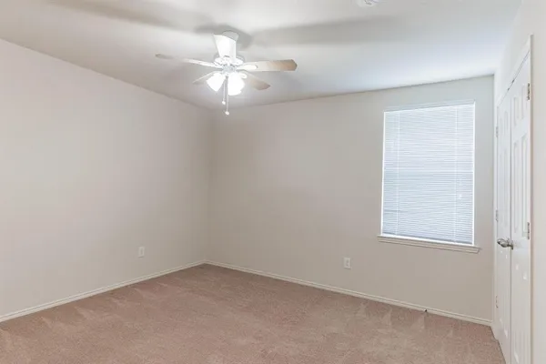 an empty room with a chandelier fan