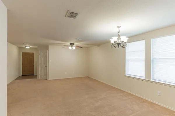 en empty room with windows and ceiling fan