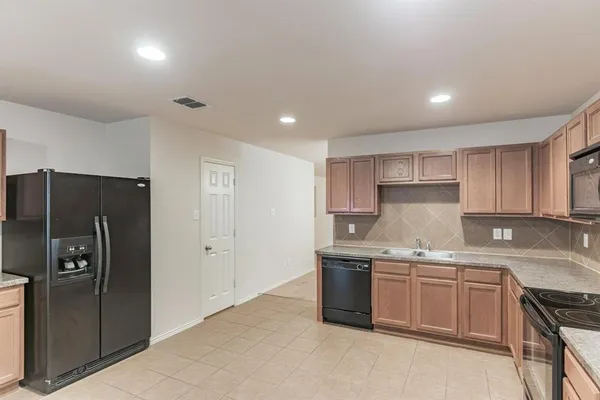 a kitchen with stainless steel appliances a sink stove and refrigerator