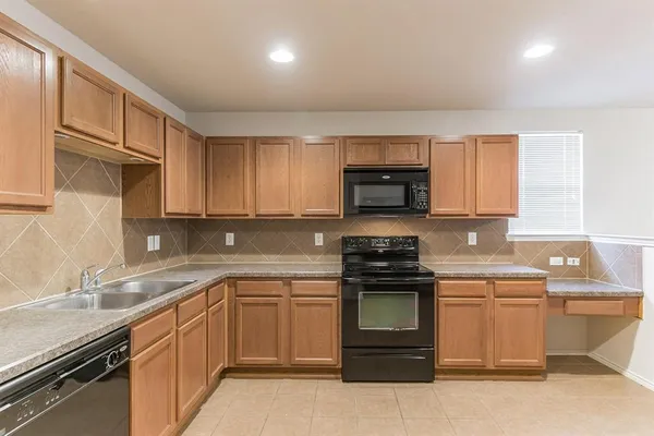 a kitchen with sink a microwave and cabinets