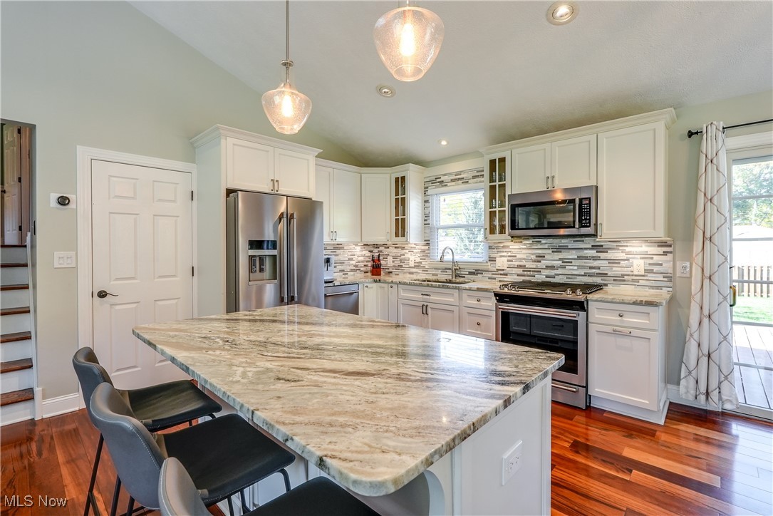 8296 Wright Road Broadview Heights, OH 44147 - Photo 11 of 45 Kitchen featuring sink, a center island, stainless steel appliances, lofted ceiling, and pendant lighting