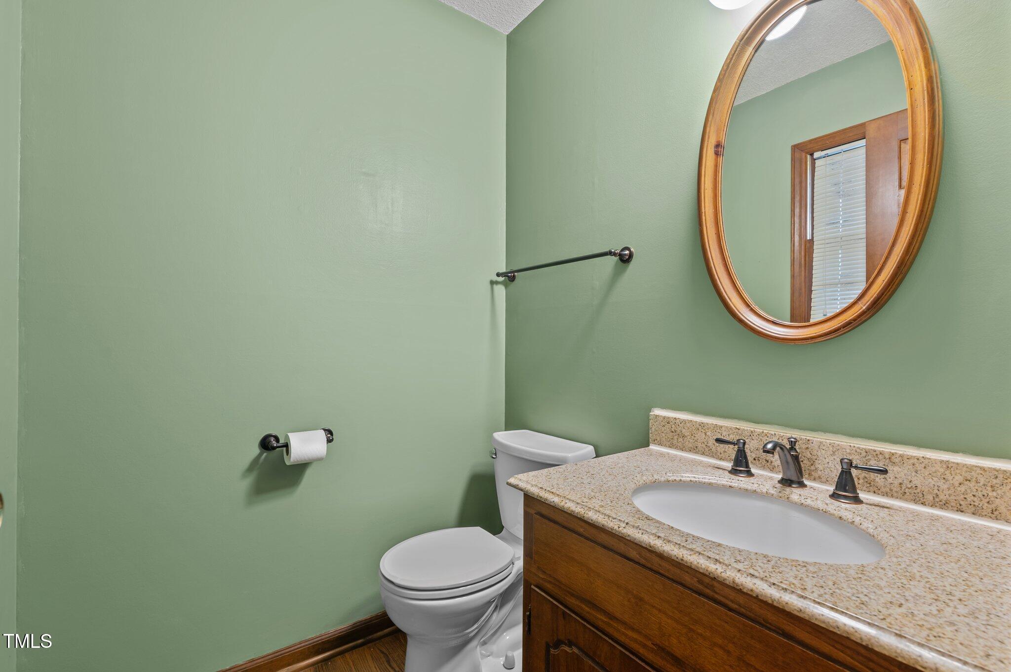 8404 Sleepy Creek Drive Raleigh, NC 27613 - Photo 14 of 39 a bathroom with a granite countertop toilet sink and mirror