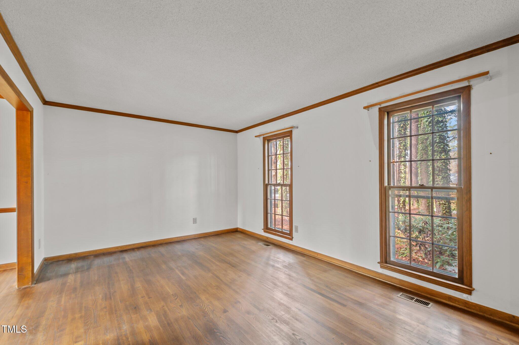 8404 Sleepy Creek Drive Raleigh, NC 27613 - Photo 17 of 39 an empty room with wooden floor and windows