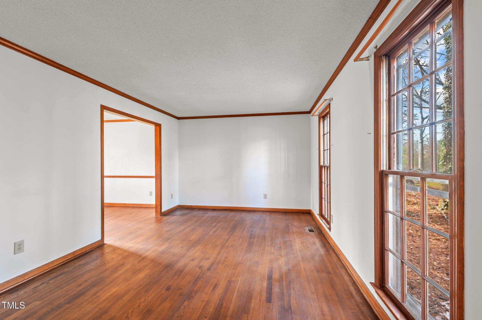 8404 Sleepy Creek Drive Raleigh, NC 27613 - Photo 18 of 39 a view of an empty room with wooden floor and a window