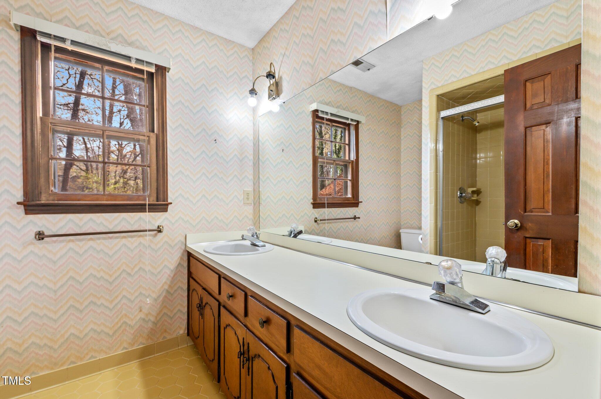 8404 Sleepy Creek Drive Raleigh, NC 27613 - Photo 25 of 39 a bathroom with a sink and a mirror