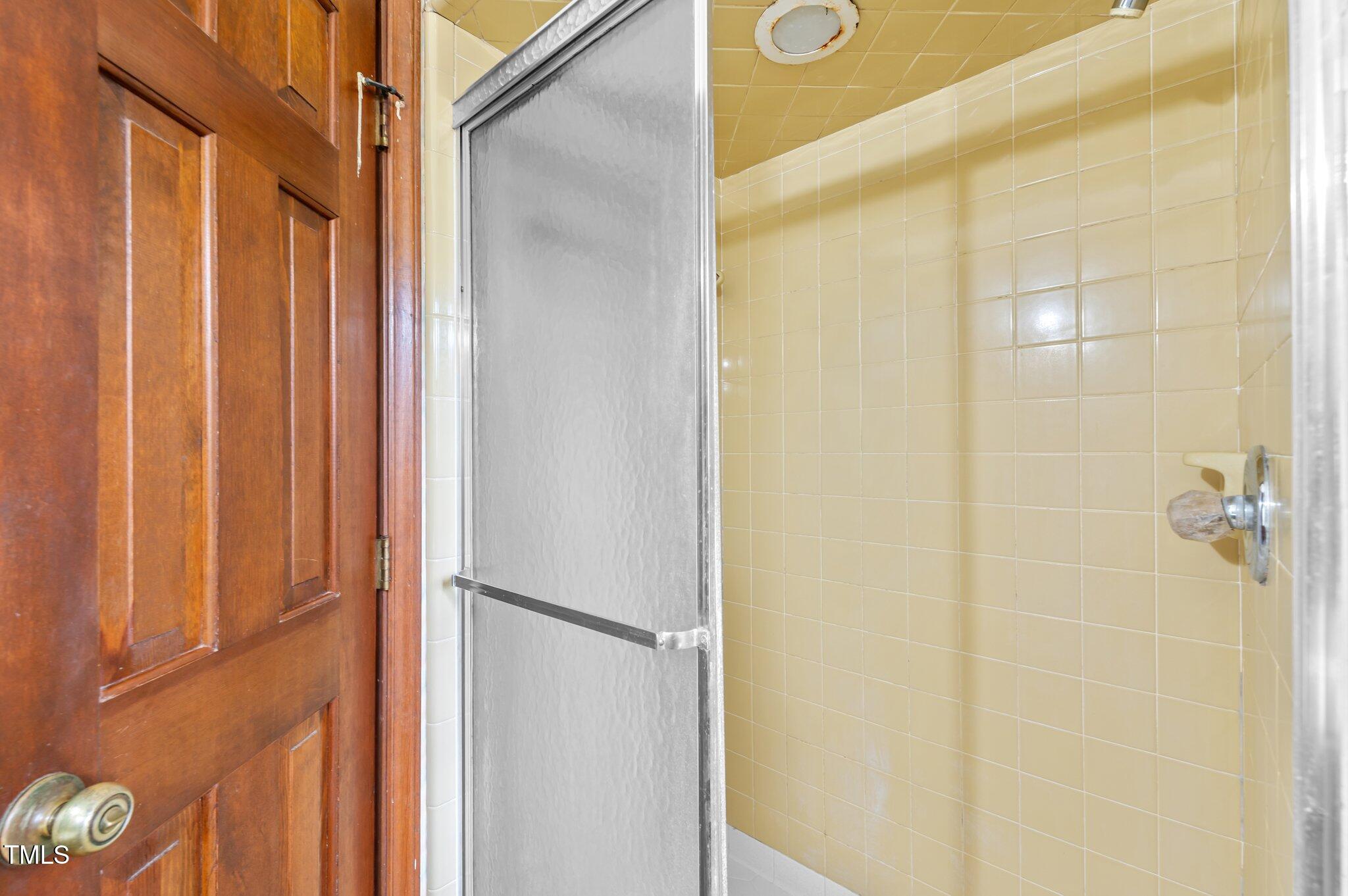 8404 Sleepy Creek Drive Raleigh, NC 27613 - Photo 26 of 39 a bathroom with a shower and a door