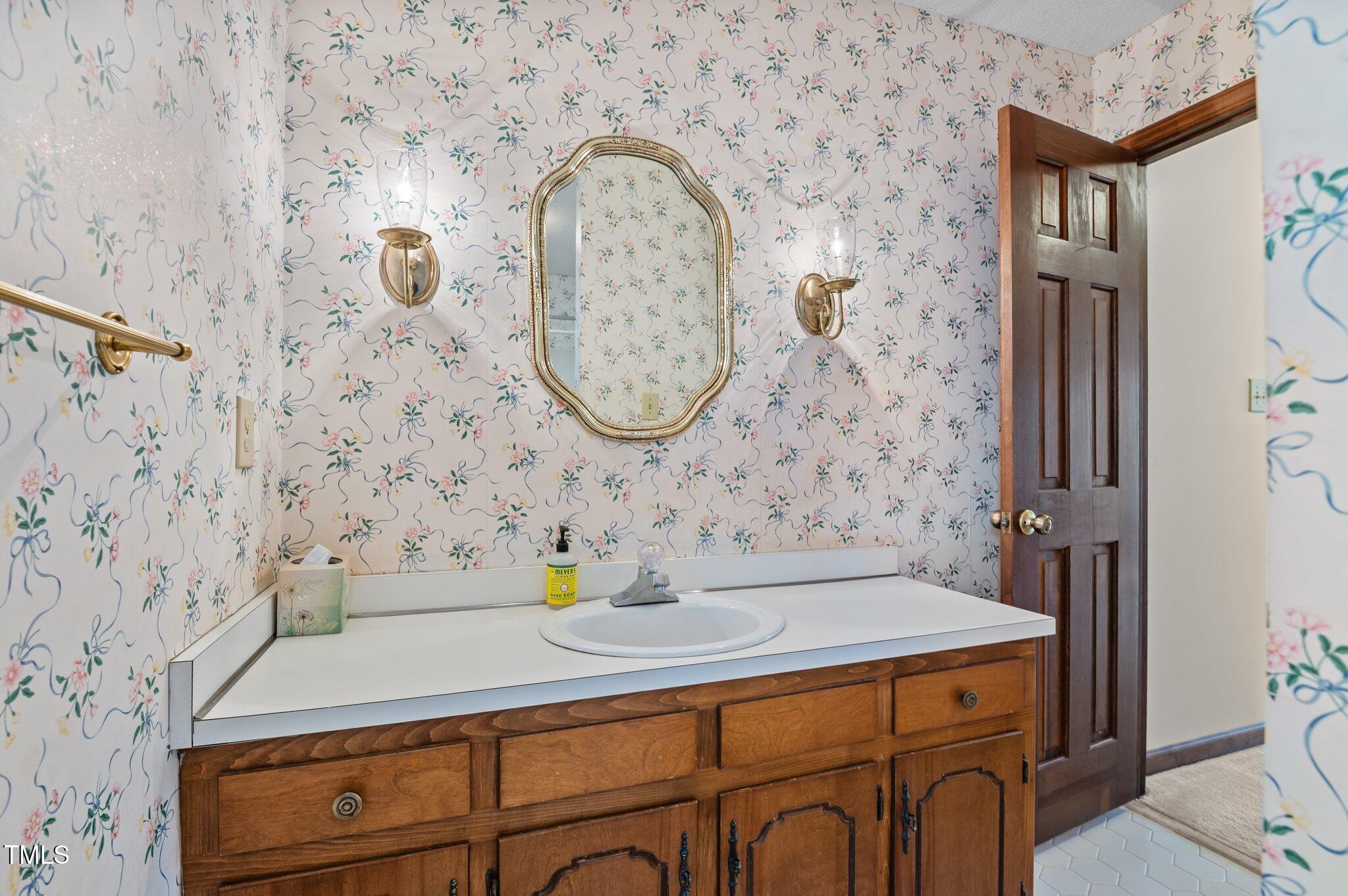 8404 Sleepy Creek Drive Raleigh, NC 27613 - Photo 30 of 39 a bathroom with a sink and a mirror