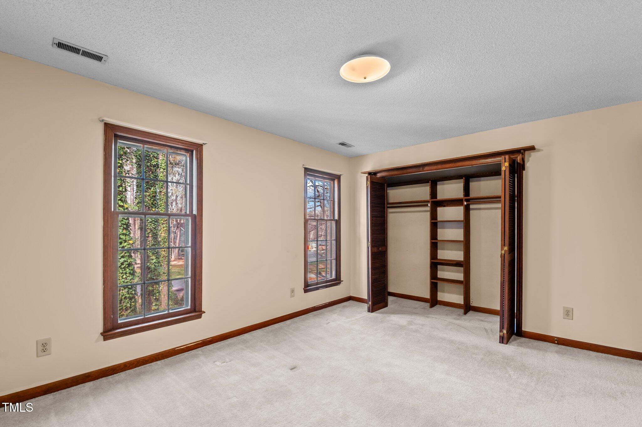 8404 Sleepy Creek Drive Raleigh, NC 27613 - Photo 31 of 39 an empty room with windows and closet