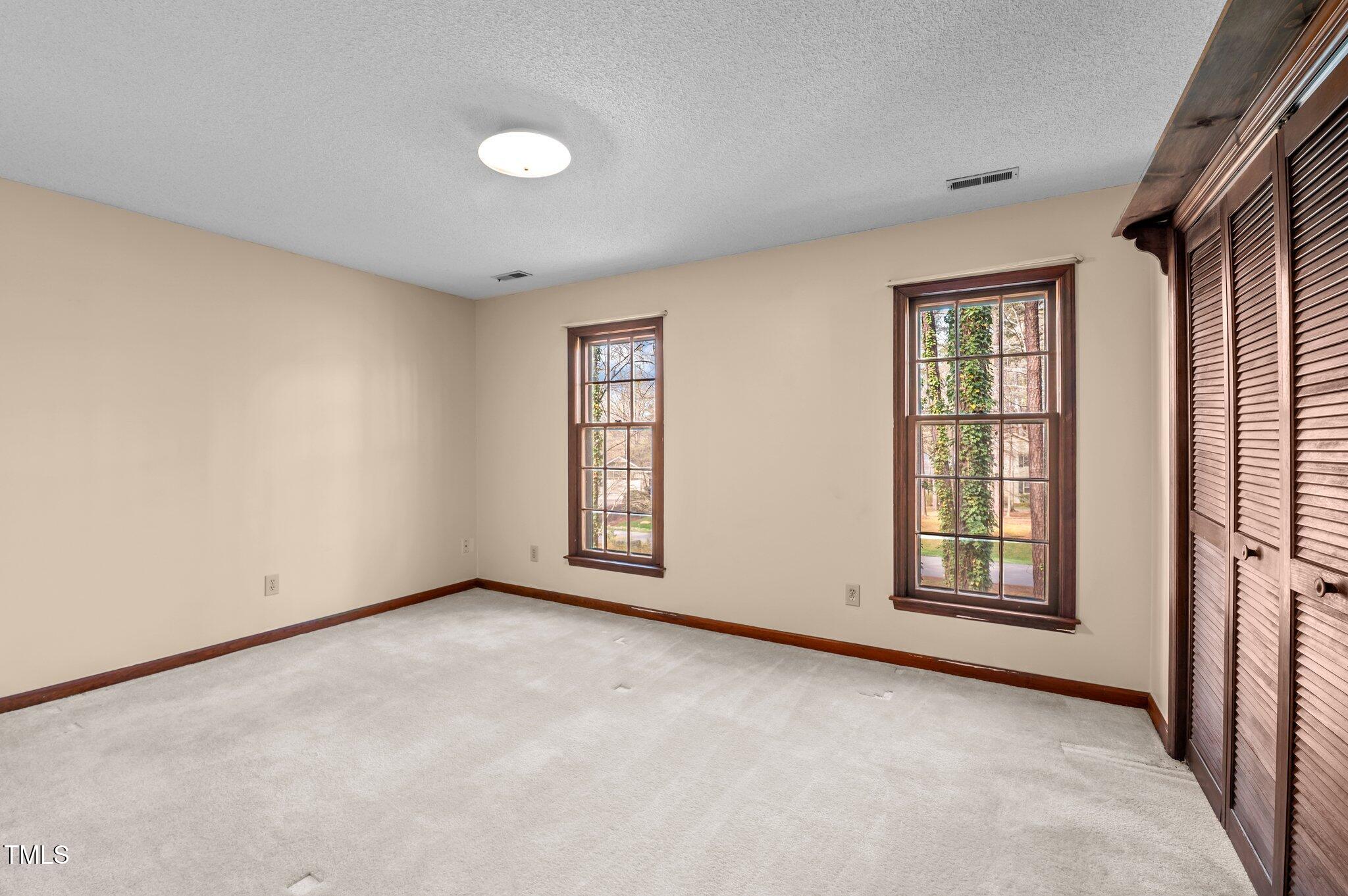 8404 Sleepy Creek Drive Raleigh, NC 27613 - Photo 32 of 39 an empty room with windows and closet