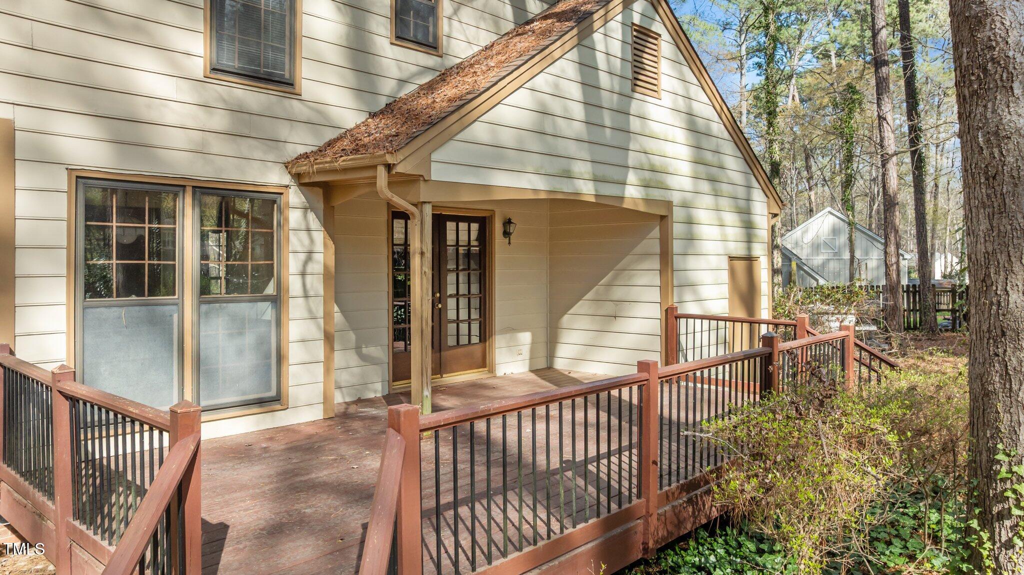8404 Sleepy Creek Drive Raleigh, NC 27613 - Photo 36 of 39 a view of a porch with a floor to ceiling window and wooden fence