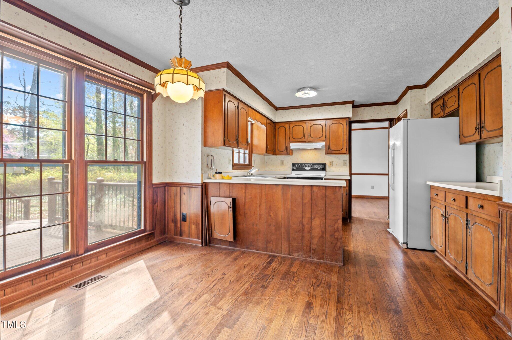 8404 Sleepy Creek Drive Raleigh, NC 27613 - Photo 8 of 39 a kitchen with stainless steel appliances granite countertop a refrigerator a stove and a wooden floors