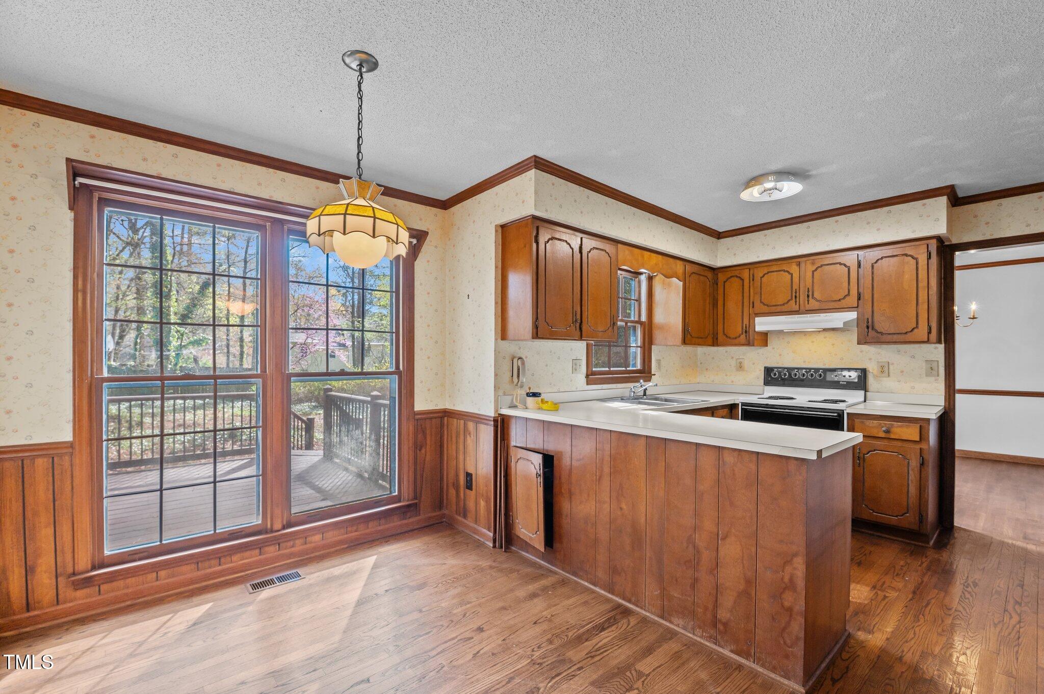 8404 Sleepy Creek Drive Raleigh, NC 27613 - Photo 9 of 39 a kitchen with stainless steel appliances granite countertop a refrigerator a sink dishwasher a stove and a dining table with wooden floor