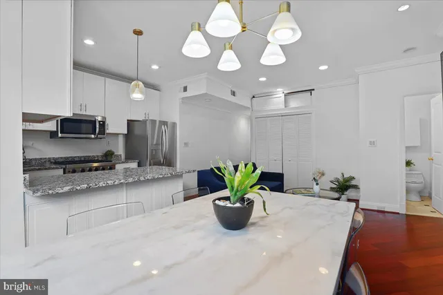 a kitchen with stainless steel appliances granite countertop wooden cabinets a stove a sink and a window