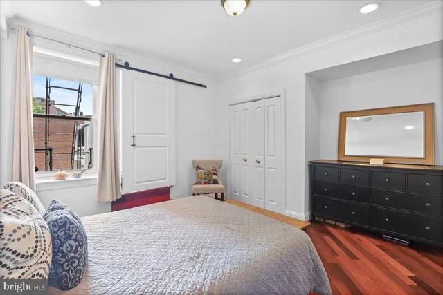 a bedroom with baby bed and wooden floor