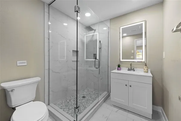 a bathroom with a shower a toilet and sink