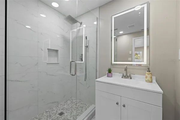 a bathroom with a sink a toilet a shower and a mirror