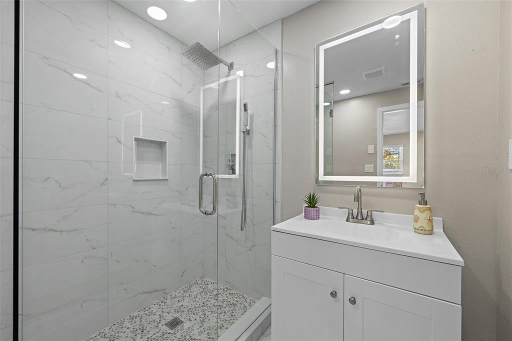 2506 Bay Boulevard Indian Rocks Beach, FL 33785 - Photo 16 of 36 a bathroom with a sink a toilet a shower and a mirror