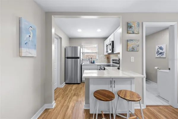 a kitchen with stainless steel appliances granite countertop a refrigerator and a stove top oven