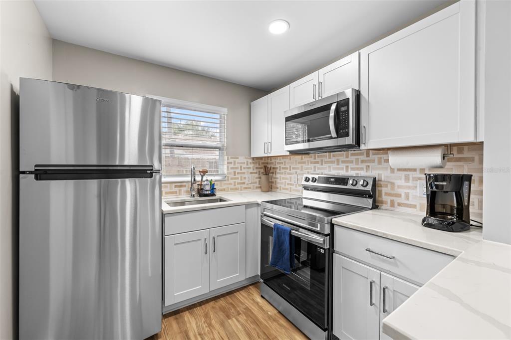 2506 Bay Boulevard Indian Rocks Beach, FL 33785 - Photo 21 of 36 a kitchen with stainless steel appliances granite countertop a refrigerator sink and stove