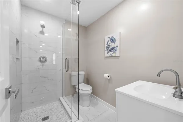 a bathroom with a sink a toilet and shower