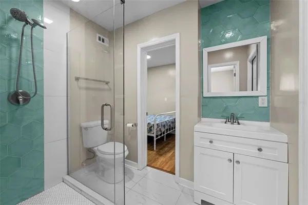 a bathroom with a sink a toilet and shower