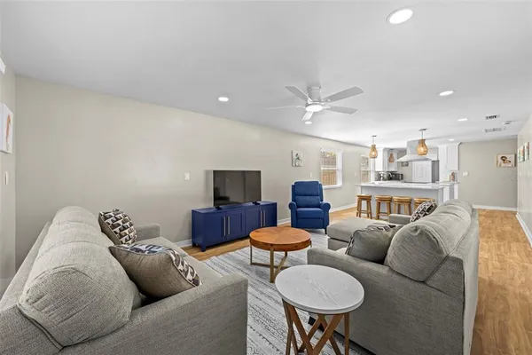 a living room with furniture a ceiling fan and a rug