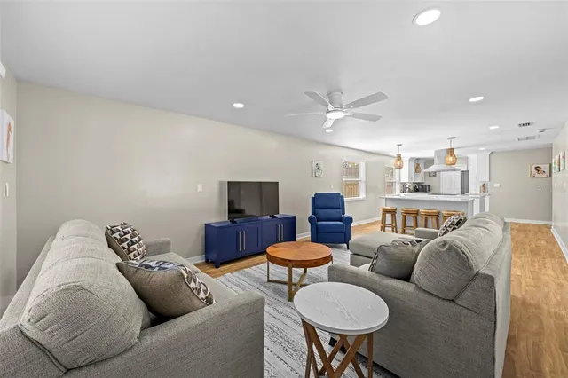 a living room with furniture a ceiling fan and a rug