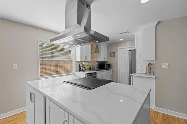 a kitchen with stainless steel appliances a sink stove and cabinets