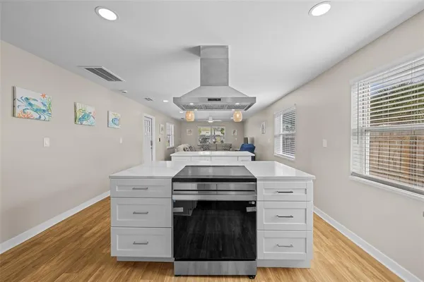 a kitchen with a stove cabinets and wooden floor