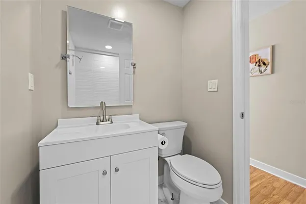 a bathroom with a toilet sink vanity and mirror