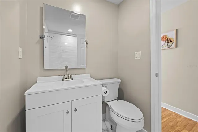 a bathroom with a toilet sink vanity and mirror