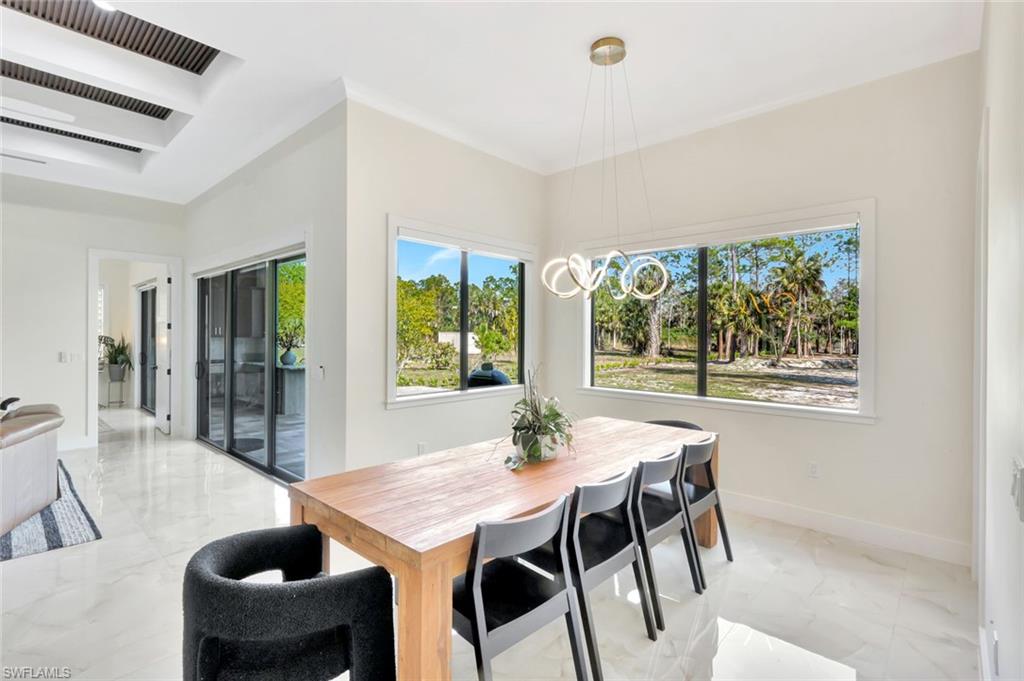 2546 4th Street Northwest Naples, FL 34120 - Photo 13 of 44 Dining space featuring light marble finish flooring, cooling unit, and a chandelier