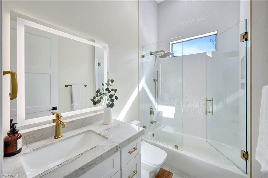 2546 4th Street Northwest Naples, FL 34120 - Photo 20 of 44 a bathroom with a granite countertop sink and a mirror with bathtub