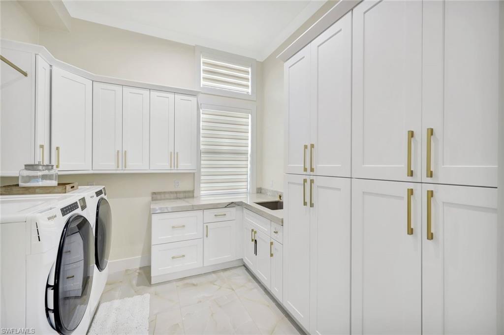 2546 4th Street Northwest Naples, FL 34120 - Photo 24 of 44 Laundry room with washer and clothes dryer, cabinet space, and light marble finish floors