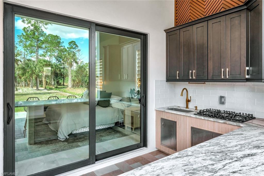 2546 4th Street Northwest Naples, FL 34120 - Photo 27 of 44 a kitchen with granite countertop a stove a sink and a wooden cabinets