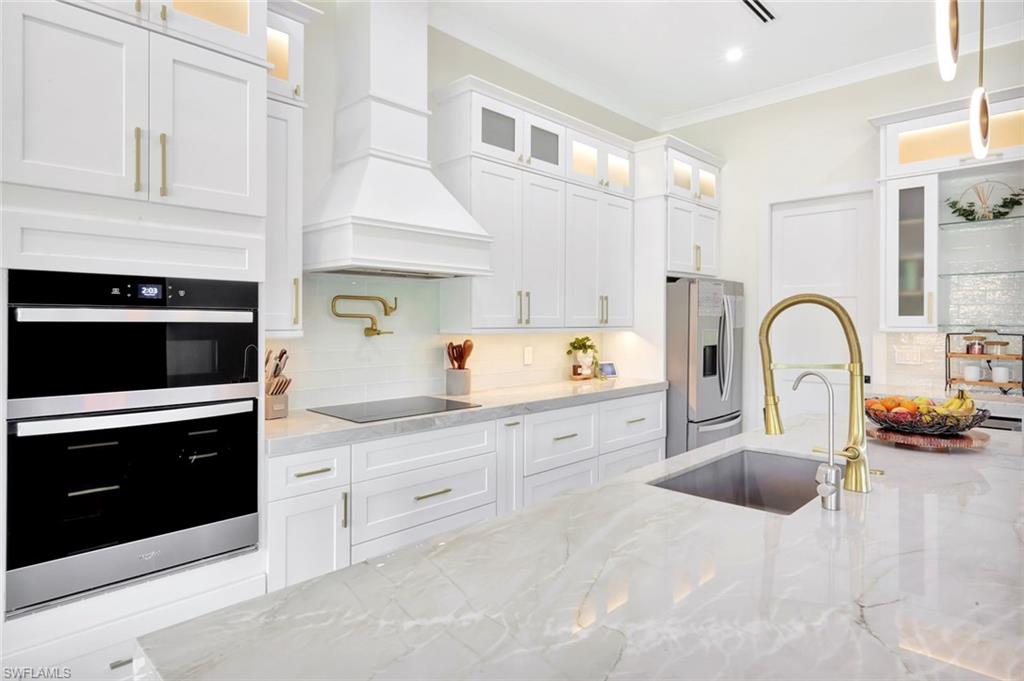 2546 4th Street Northwest Naples, FL 34120 - Photo 10 of 44 a kitchen with white cabinets and sink