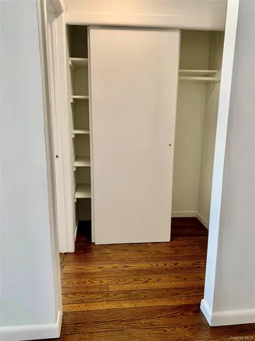 a view of walk in closet with wooden floor