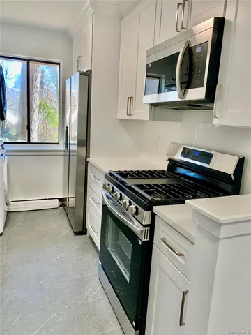 a kitchen with stainless steel appliances a stove a microwave and a sink