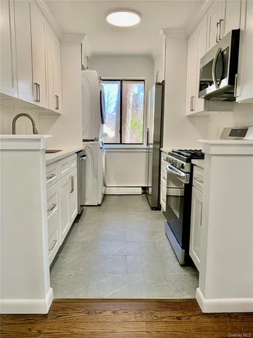 a kitchen with white cabinets and stainless steel appliances