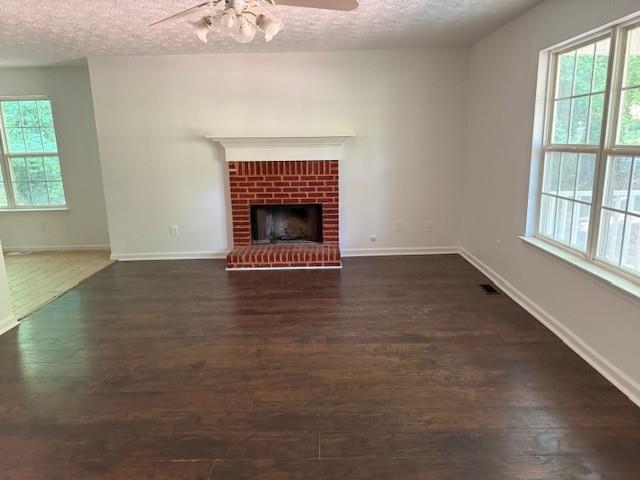 2196 Stenger Road Douglasville, GA 30135 - Photo 3 of 13 an empty room with wooden floor fireplace and windows