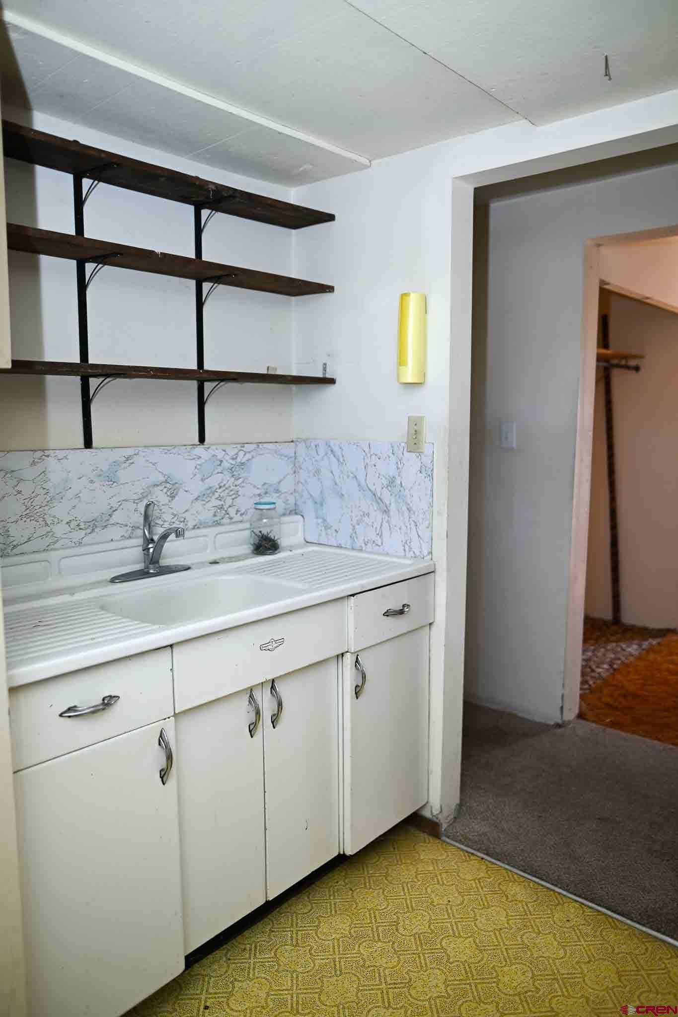 22120 Government Springs Road Montrose, CO 81403 - Photo 21 of 28 a view of a kitchen with cabinets and wooden floor