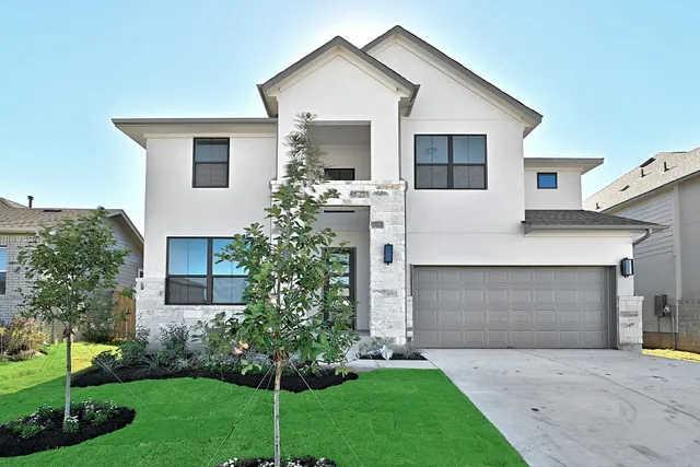 a front view of a house with a yard and garage