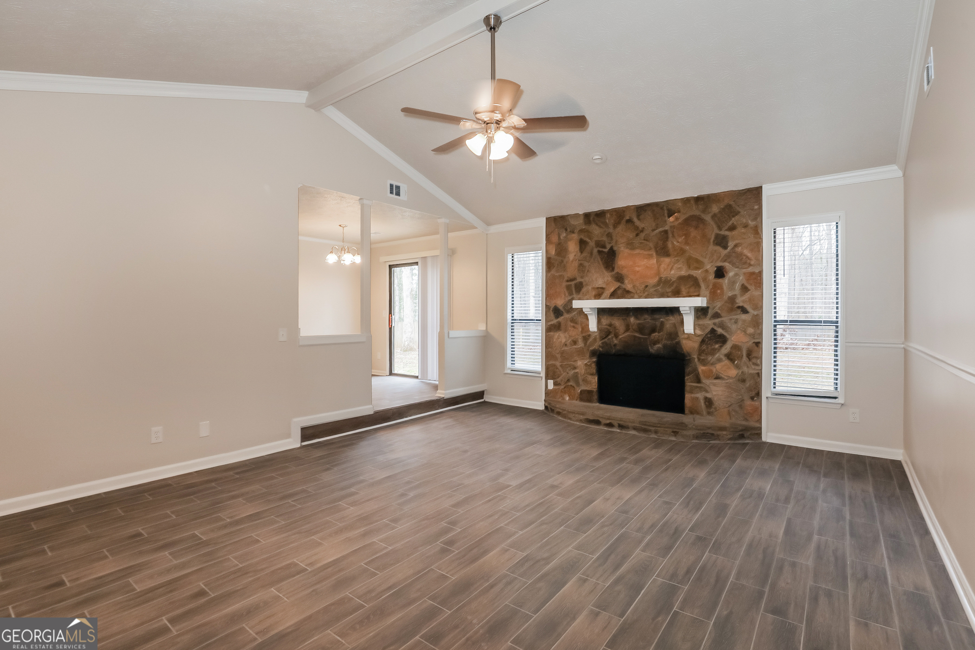 125 Whitney Way Fayetteville, GA 30214 - Photo 2 of 16 an empty room with wooden floor fireplace and windows