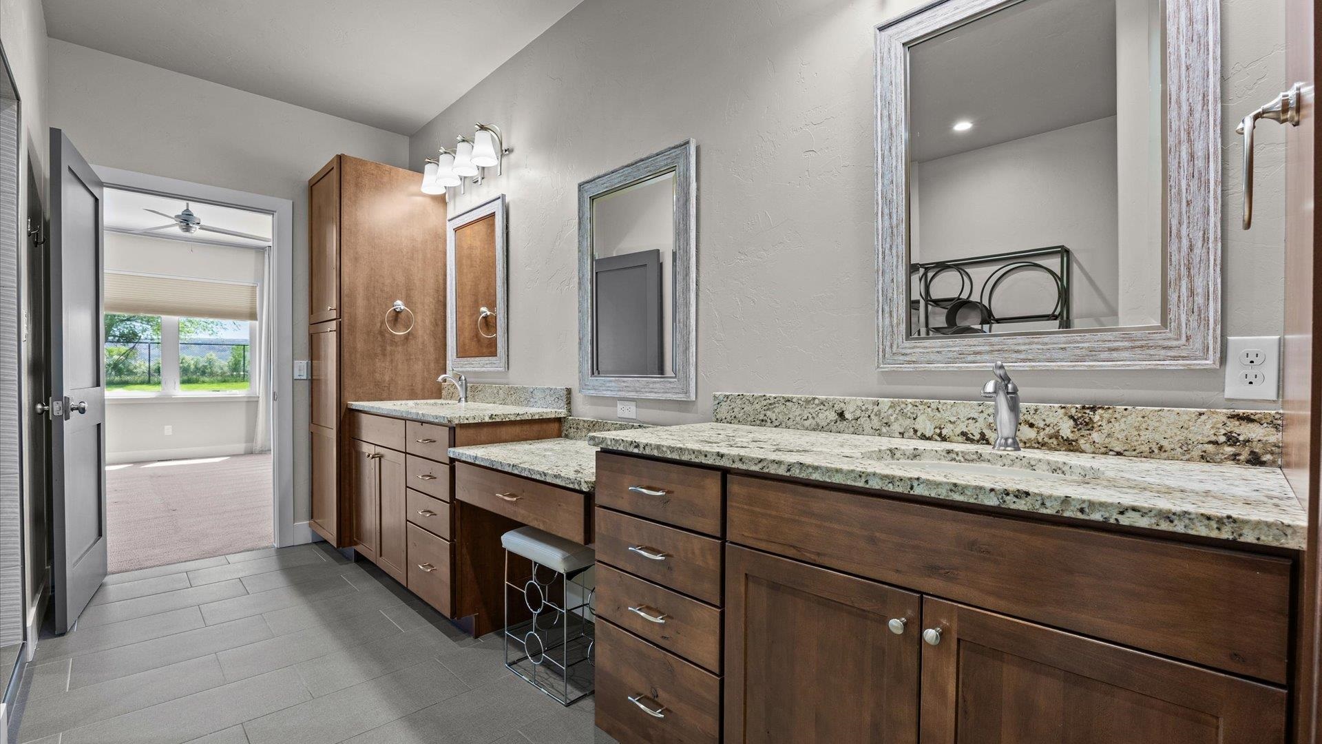 2041 J J 1/2 Road Fruita, CO 81521 - Photo 18 of 42 a bathroom with a granite countertop sink double vanity and a mirror
