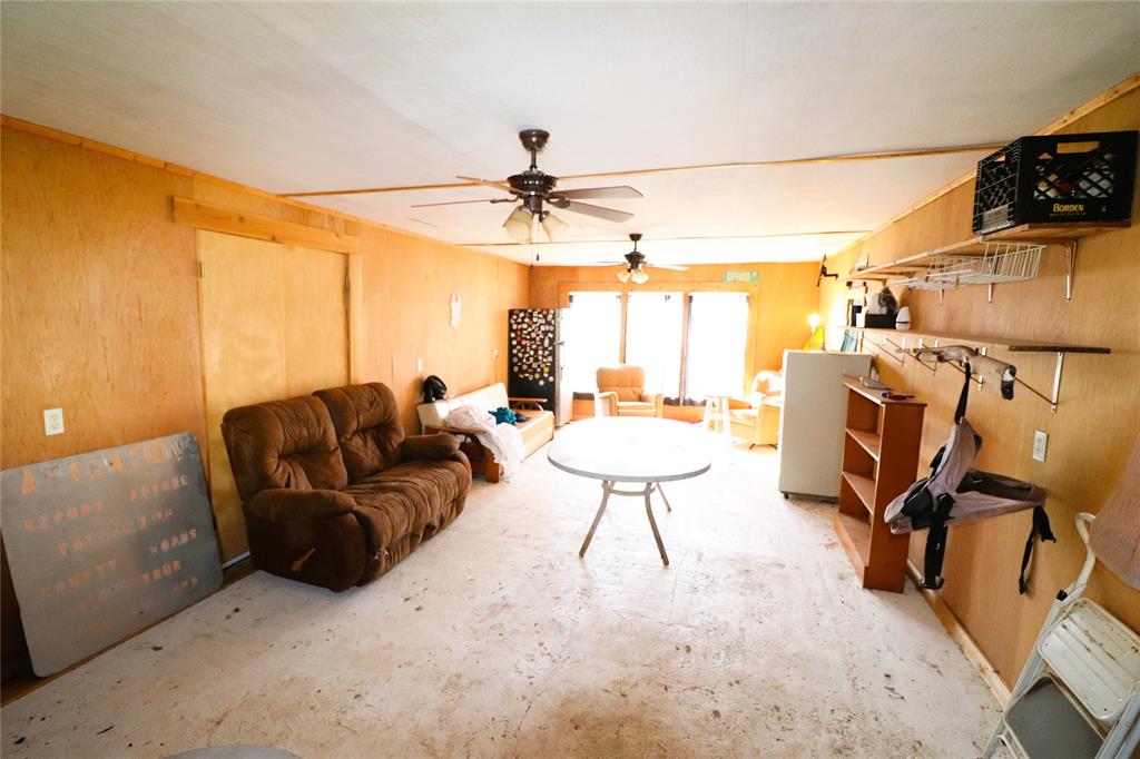 10543 Old Joy Shannon Road Henrietta, TX 76365 - Photo 21 of 36 a living room with furniture a chandelier and a flat screen tv