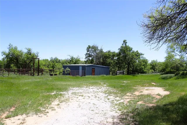 a view of a big yard with large trees