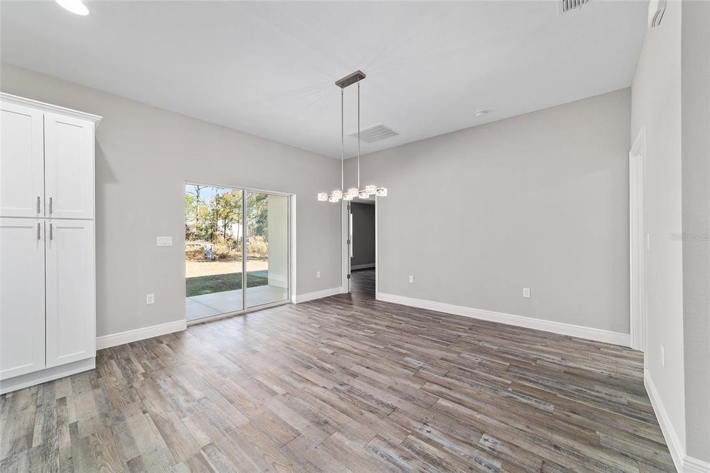 13359 Southwest 80th Street Dunnellon, FL 34432 - Photo 19 of 64 a view of an empty room with wooden floor and a window