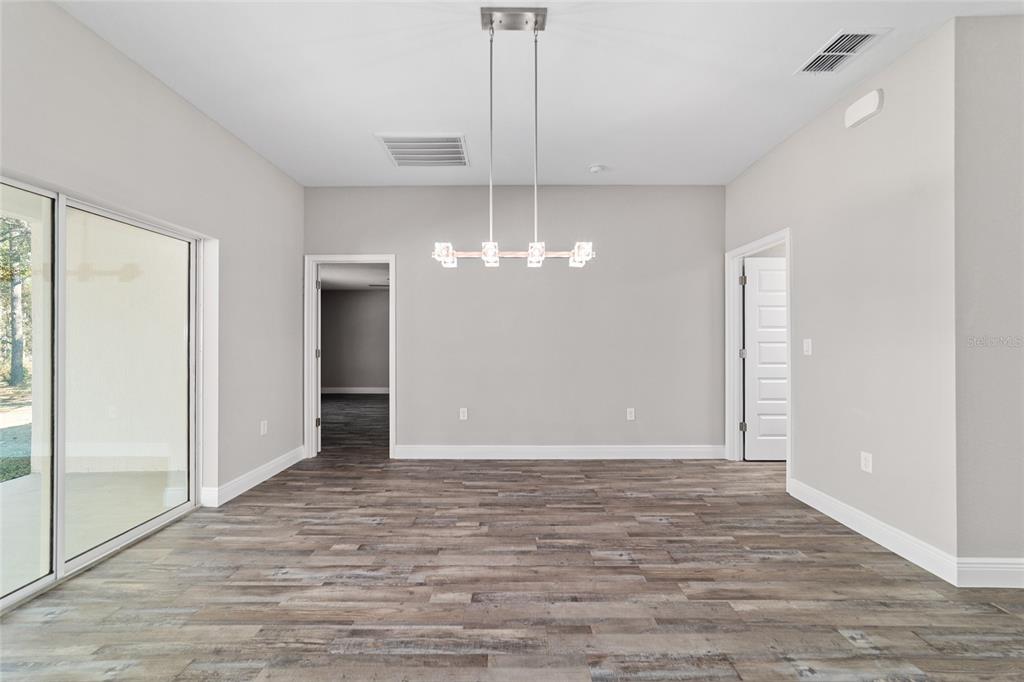 13359 Southwest 80th Street Dunnellon, FL 34432 - Photo 24 of 64 wooden floor in an empty room with a window